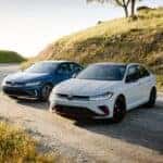 Two Fashionable And Reliable Volkswagen Jettas, Parked On A Road Winding Around A Hill