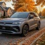 2026 Volkswagen Tiguan on a tree-lined Olathe street in fall, surrounded by autumn leaves