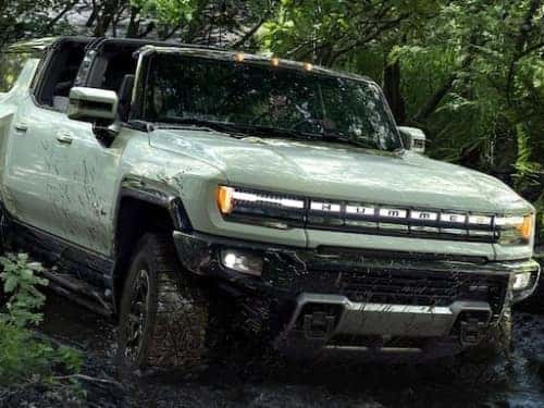 2024 Hummer EV SUV offroading through muddy trails