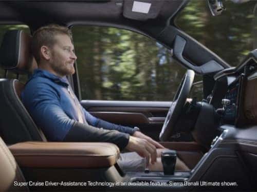 2024 GMC Sierra 1500 Denali side view of man in front driver seat while vehicle drivers using super cruise feature