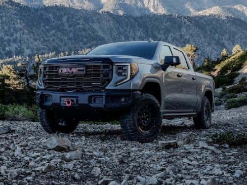 2024 GMC Sierra 1500 AT4 exterior view parked in rocks with mountains in background