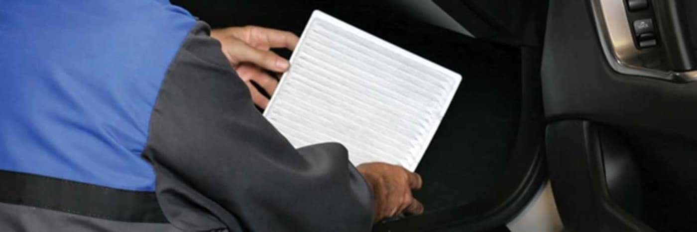 Close up view of a service tech changing out a cabin air filter