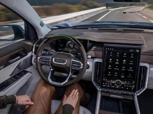 2024 GMC Acadia view of person in driver seat with hands off of wheel while vehicle is in super cruise mode
