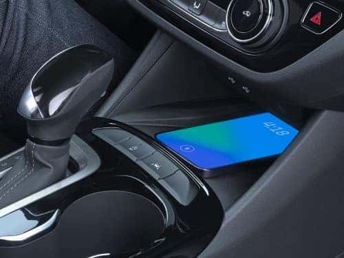 2025 Buick Envista Sport Touring close up view of center console with phone on wireless charger