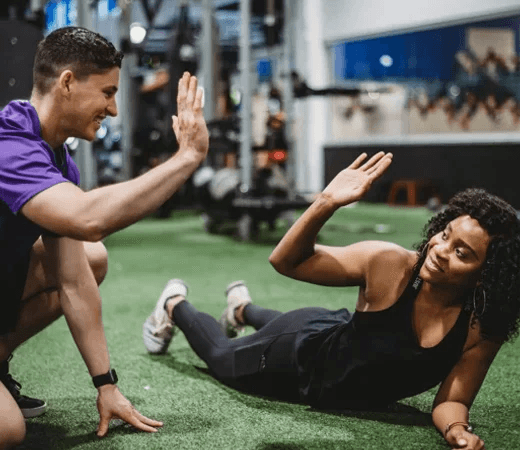 Two People High-Fiving at Gym