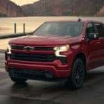 A red 2023 Chevy Silverado 1500 Z71 is shown parked in front of a lake.