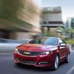 A red 2018 Chevy Impala LTZ is shown speeding on a city street.
