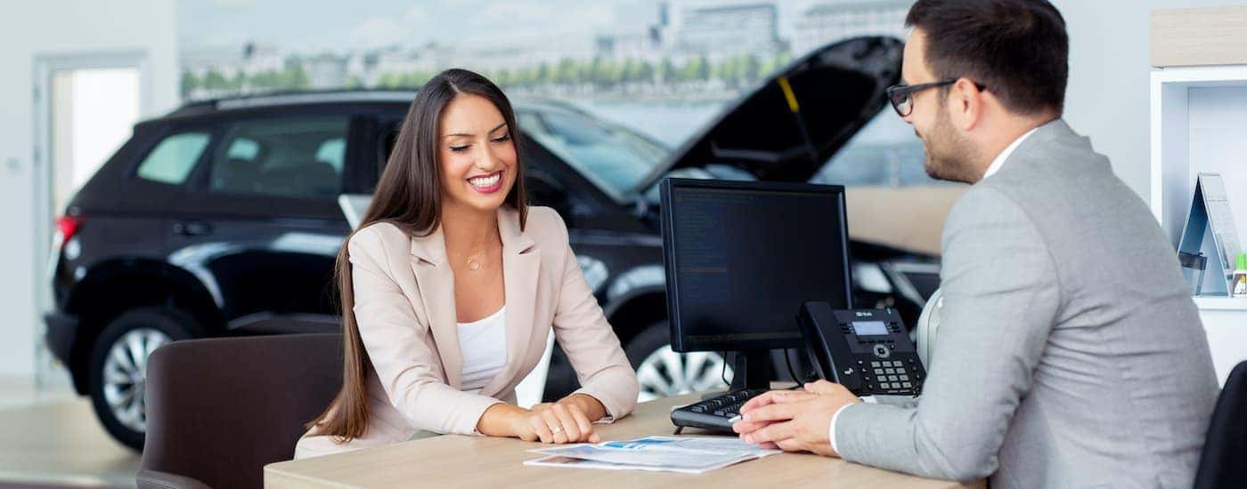 A salesperson is shown talking to a customer at a Chevrolet dealer.