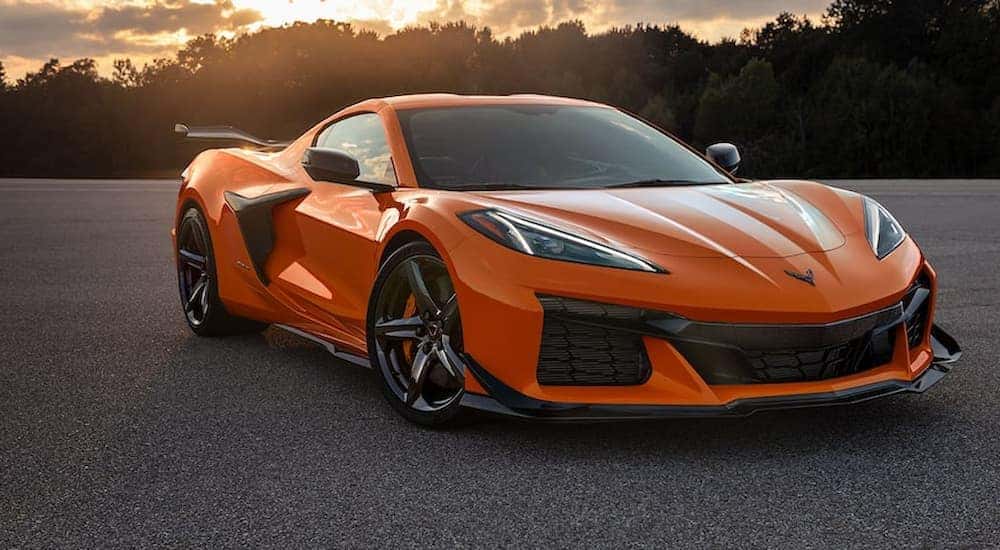 An orange 2023 Chevy Corvette Z06 is shown parked in an empty lot after leaving a Chevy dealer.