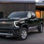 A black 2024 Chevy Silverado 1500 HD High Country is shown parked in a driveway after visiting a Chevy Silverado for sale near Bessemer.