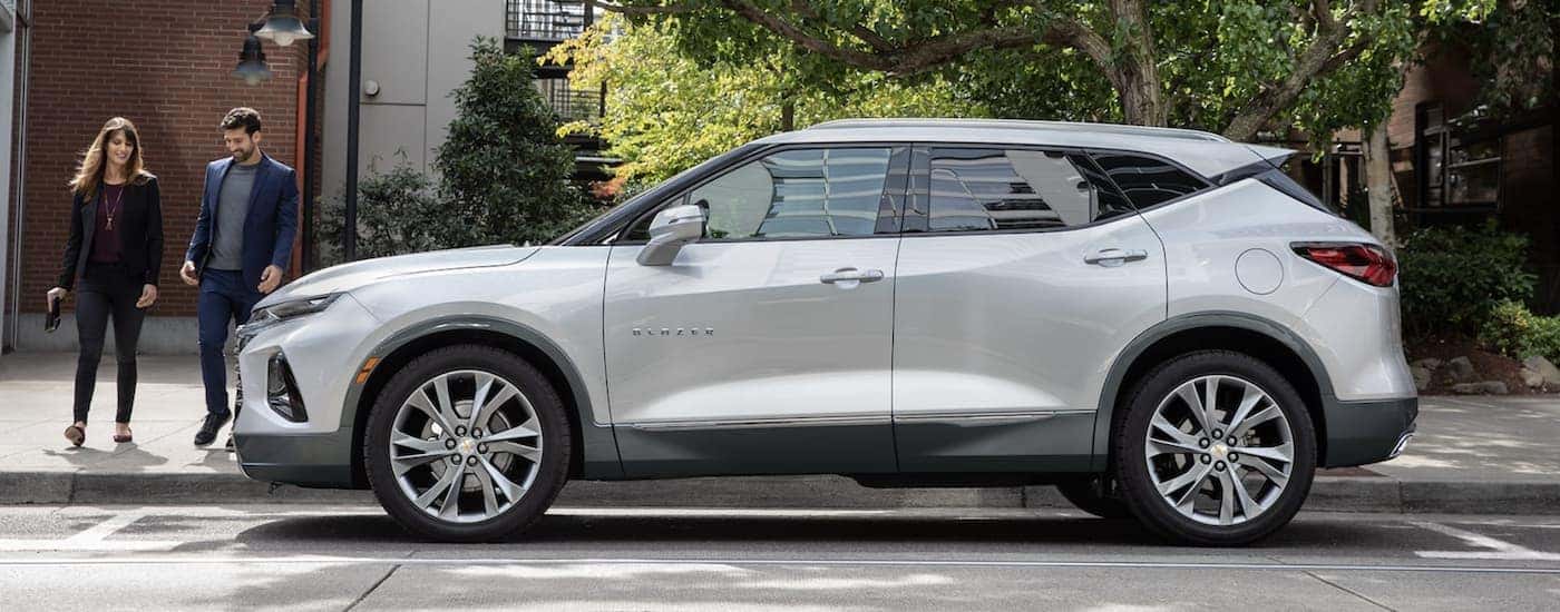 A silver 2022 Chevy Blazer is shown parker near two people.