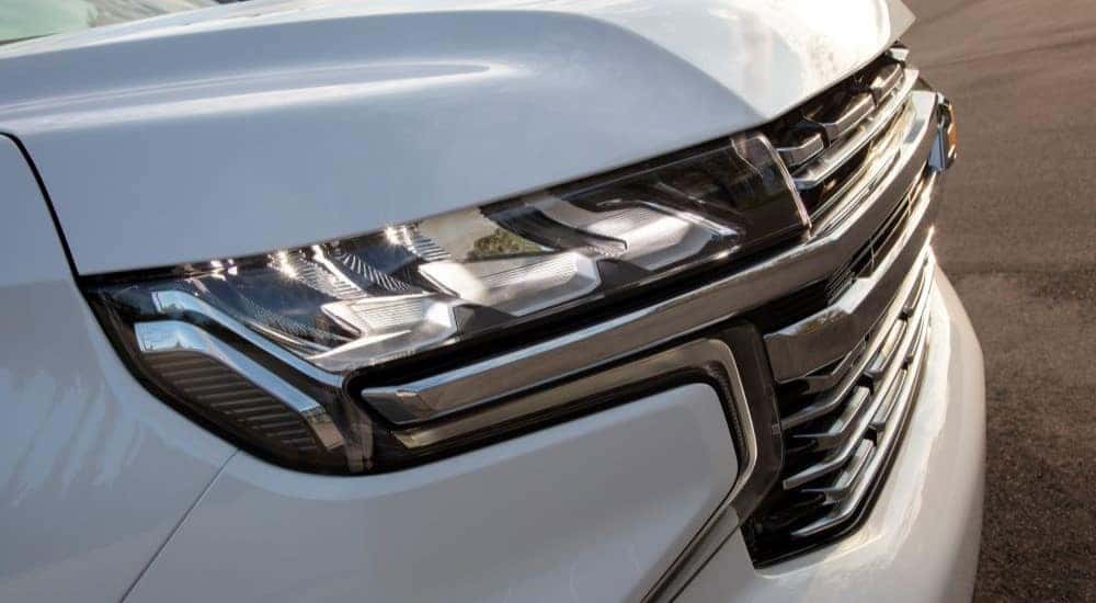 A close-up on the headlights of a white 2022 Chevy Suburban is shown.