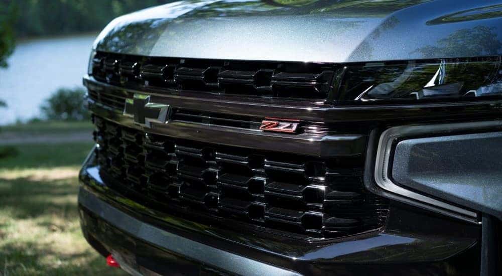 A close-up on the grille of a grey 2022 Chevy Suburban Z71 is shown.