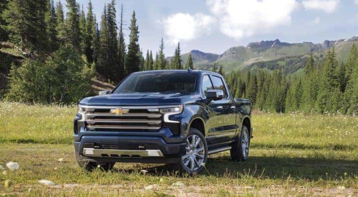 A blue 2022 Chevy Silverado 1500 High Country is shown from the front at an angle after leaving a dealer that has a used Chevy Silverado for sale.