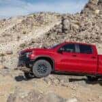 A red 2022 Chevy Silverado 1500 ZR2 is shown from the side while off-road after leaving a dealer that has a Chevy Silverado 1500 for sale.