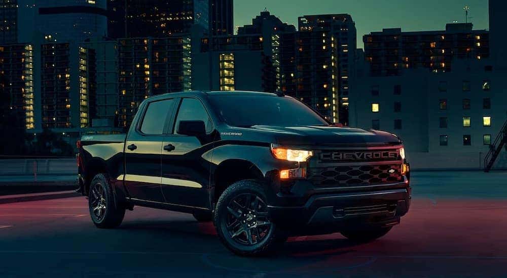 A black 2023 Chevy Silverado Custom is shown from the front at an angle.
