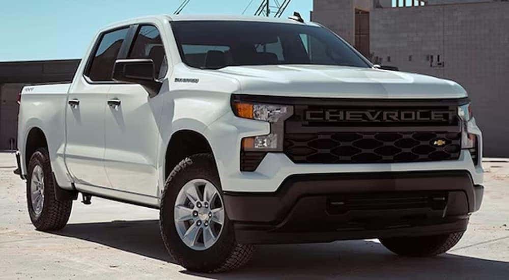 A white 2024 Chevy Silverado 1500 WT is shown parked on a construction site.