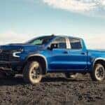 A blue 2024 Chevy Silverado 1500 ZR2, a Chevy Silverado for sale near Bessemer, parked off-road.