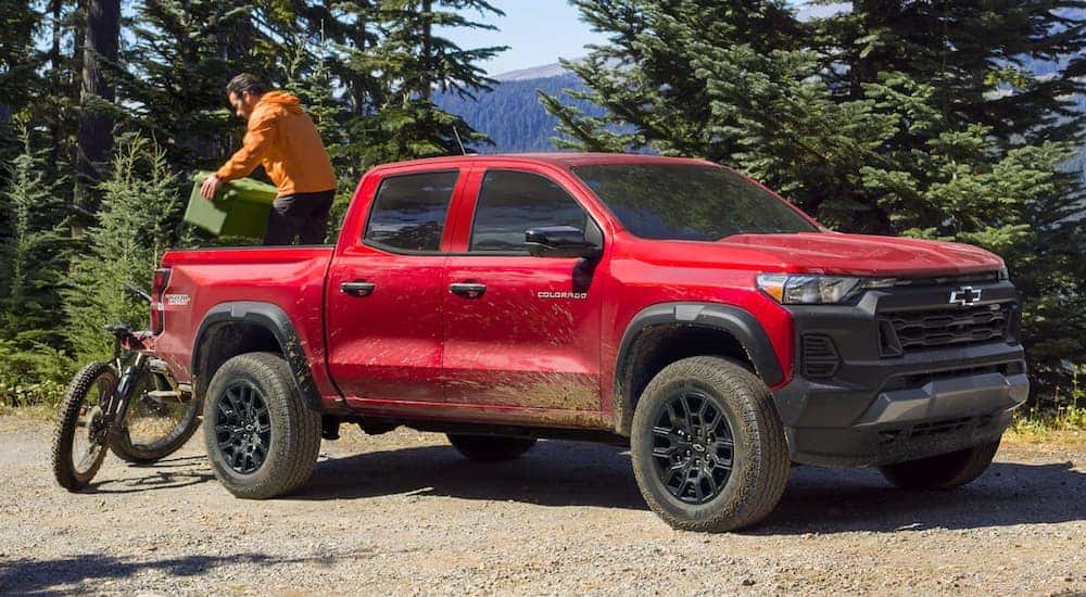 A red 2024 Chevy Colorado Trail Boss parked on a dirt road.