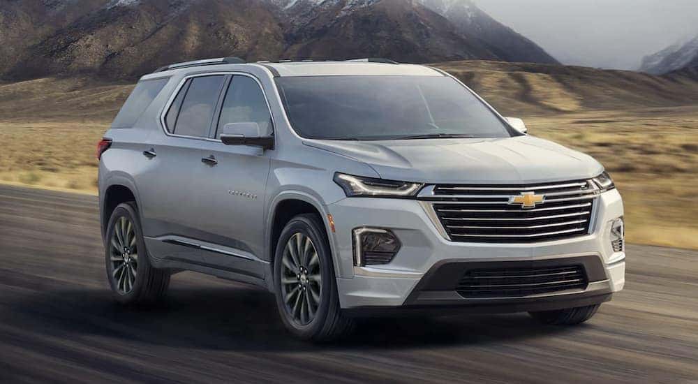 A silver 2022 Chevy Traverse is shown driving on a highway.