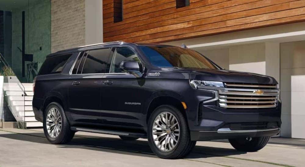 A blue 2023 Chevy Suburban High Country is shown parked near used SUVs for sale.