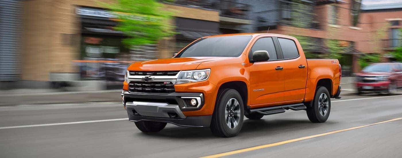 An orange 2021 Chevy Colorado for sale is shown from the side.