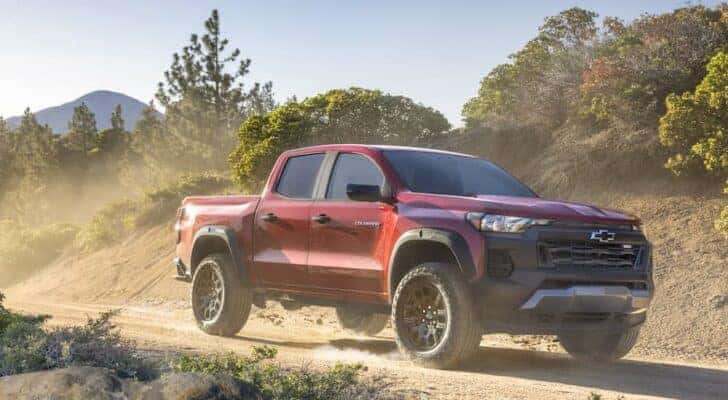 A red 2024 Chevy Colorado Trail Boss is shown from the side.