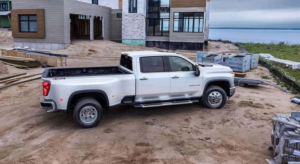 A white 2024 Chevy Silverado 3500 HD LTZ is shown parked on a construction site.