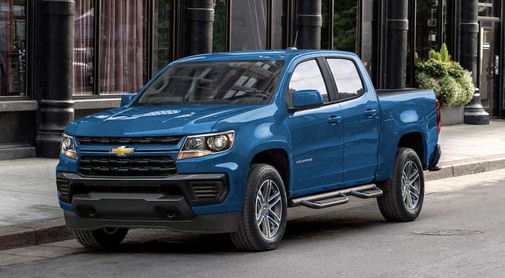 A blue 2022 Chevy Colorado is shown parked near a city curb.