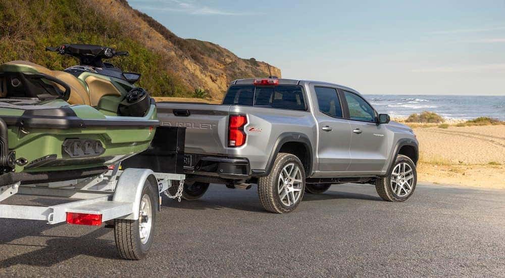 A grey 2023 Chevy Colorado Z71 towing a jetski from a truck dealer.