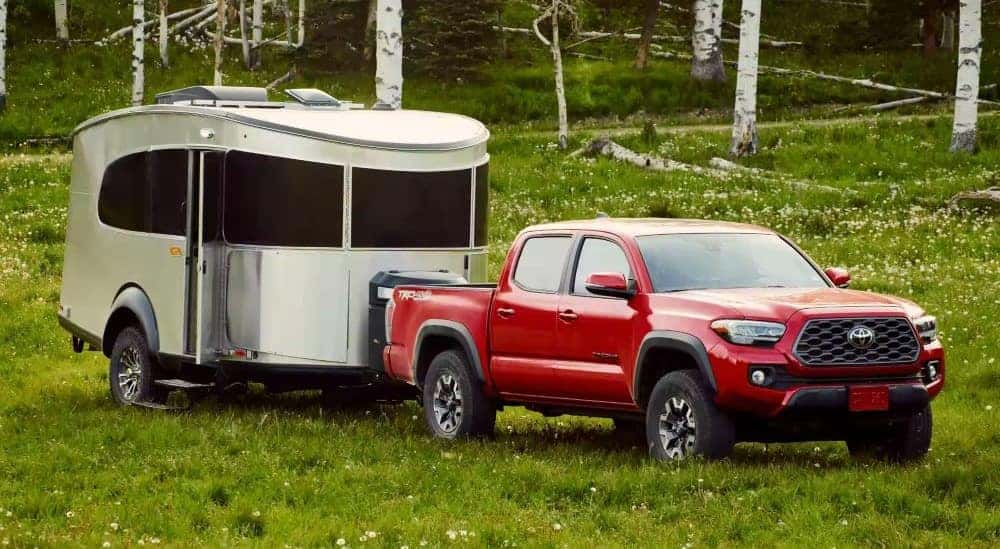 A red 2021 Toyota Tacoma TRD is shown parked while towing a trailer.