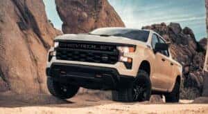 A white 2025 Chevy Silverado 1500 Z71 driving off-road in a desert.
