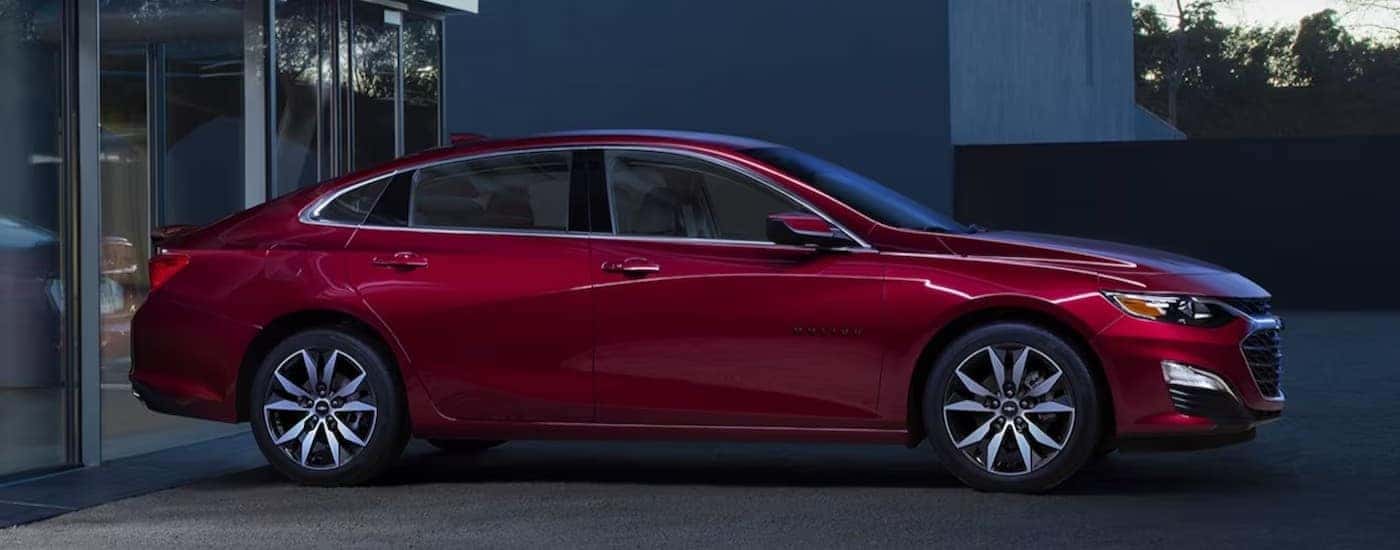 A red 2024 Chevy Malibu is shown parked on a driveway.