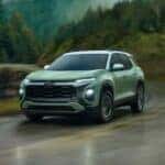 A green 2025 Chevy Equinox for sale driving on a highway.