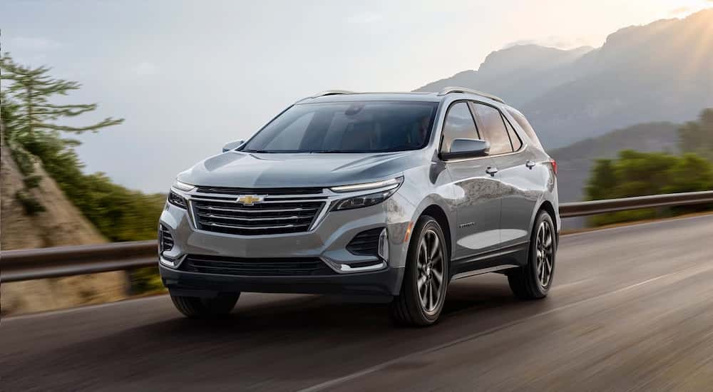 A silver 2025 Chevy Equinox driving down a road.