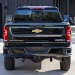 A black 2025 Chevy Silverado 2500 HD High Country parked on a driveway.