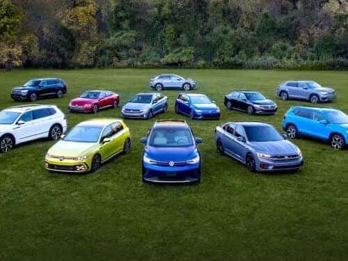 Various Volkswagen vehicles parked on a grass field.