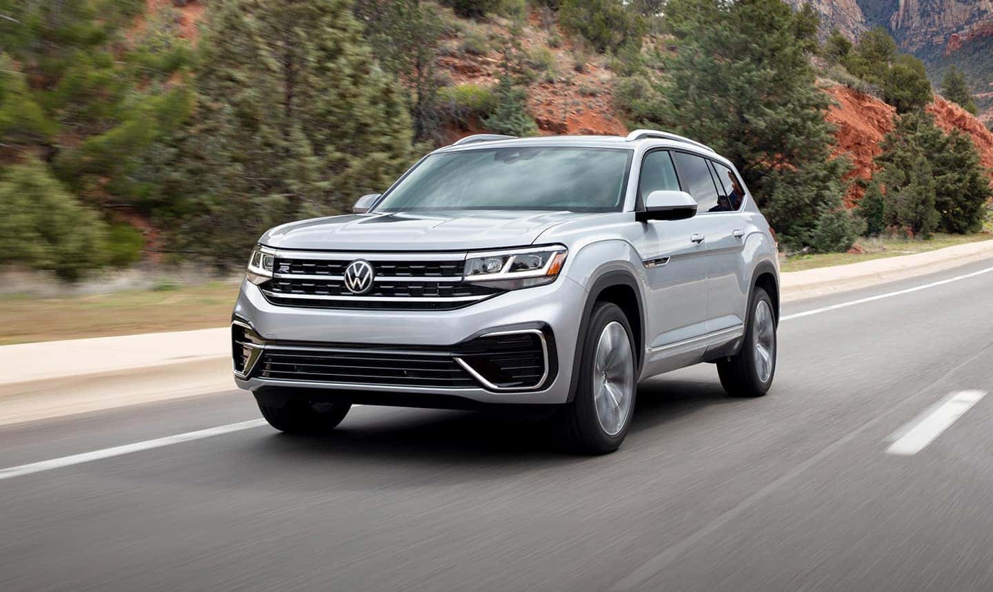 Silver Volkswagen Atlas driving on a mountainous road.