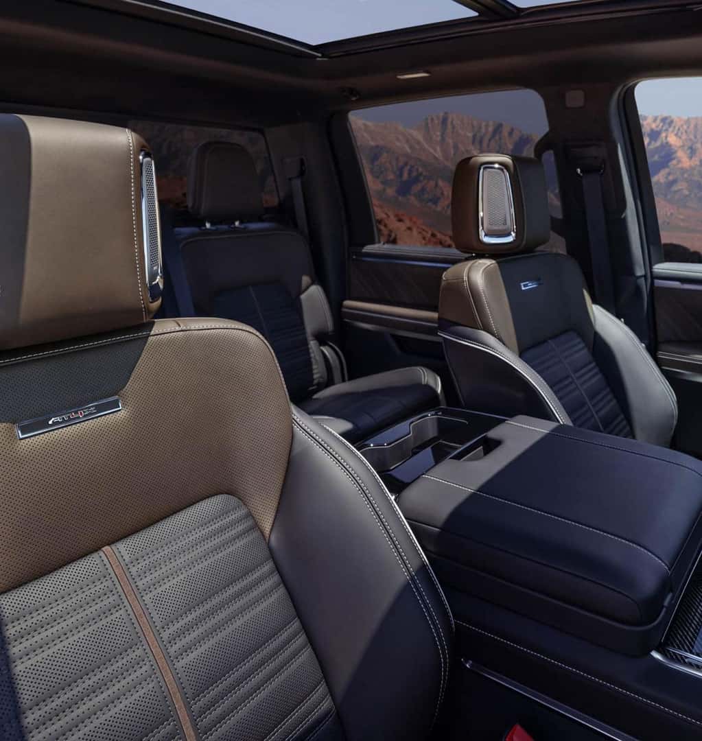 GMC Sierra 1500 2027 GMC Sierra 1500 AT4X interior featuring premium seating, headrest speakers, and a panoramic sunroof.