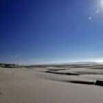 a sandy beach with a body of water in the background