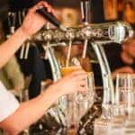 Person pouring beer at a brewery