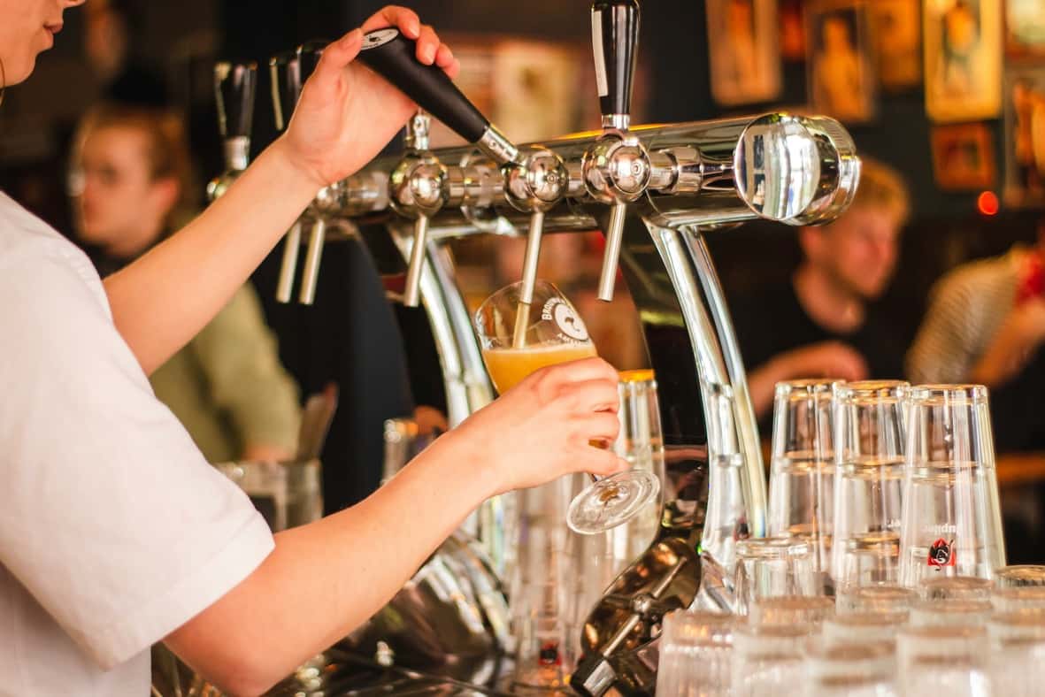 Person pouring beer at a brewery