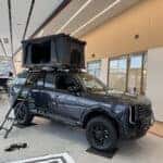 Kia Telluride with rooftop tent in a showroom