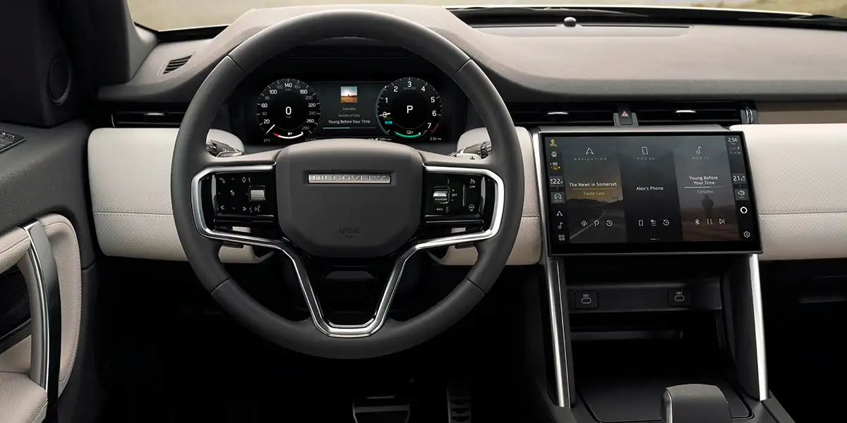 2024 Land Rover Discovery Sport interior with Luxtec and suedecloth seats, modern dashboard and panoramic sunroof.