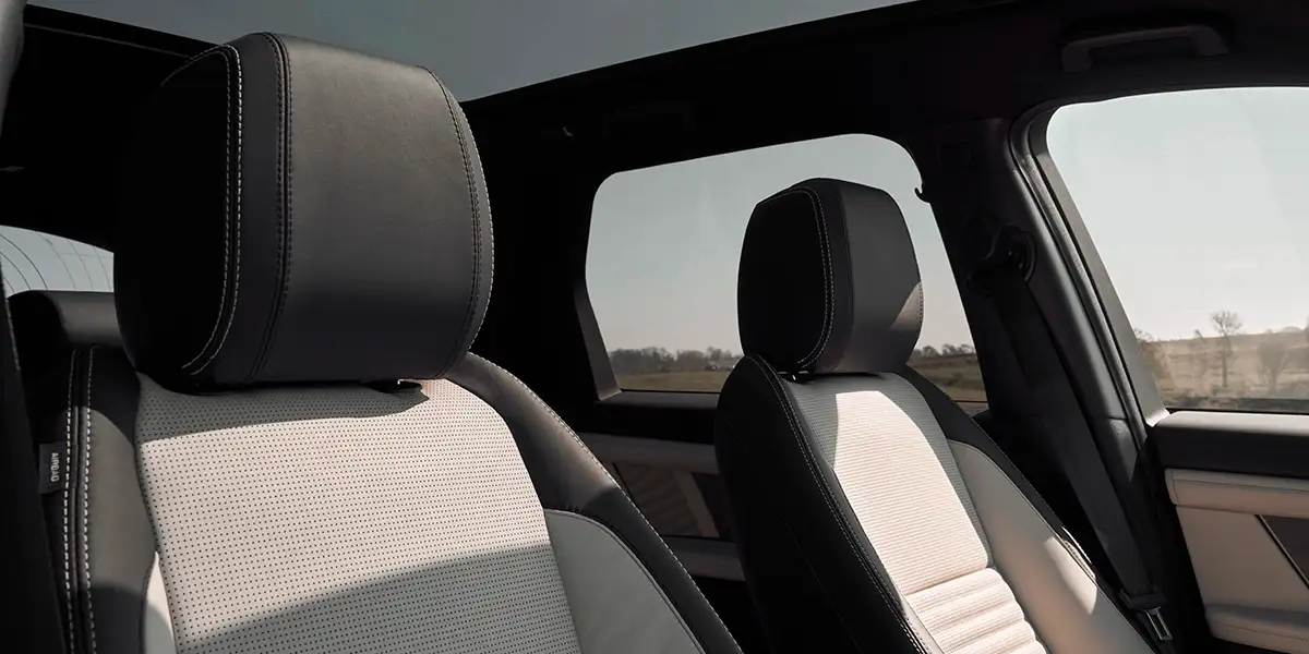 Luxury interior of 2026 Land Rover Discovery Sport with premium leather seats and panoramic glass roof.