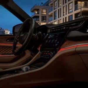Jeep Grand Cherokee interior featuring ambient LED lighting and advanced touchscreen display for a luxurious driving experience.