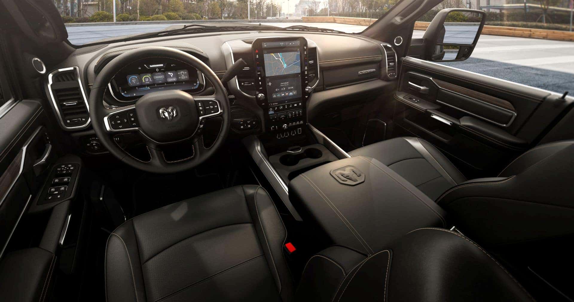 the front interior a ram 2500 showcasing the black interior with white stiching, steering wheel, infotainment display and digital cluster display.