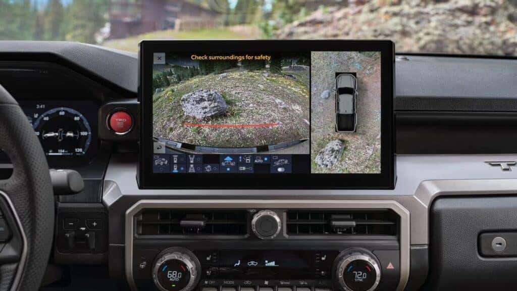 Interior view of a Toyota truck showcasing a 360-degree camera system and off-road navigation screen.