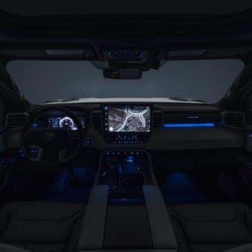 the front interior of a toyota turck with blue accent lights at night