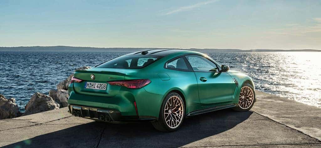 BMW M4 CS rear quarter view by a lake.